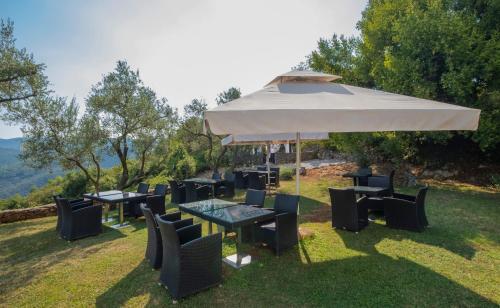 a group of tables and chairs under an umbrella at Hotel Villa Annette in Rabac