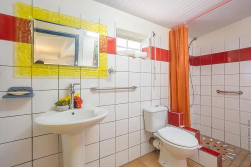 a bathroom with a toilet and a sink at Villa Cocotier in Sainte-Anne