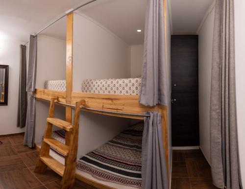 a bunk bed with a ladder in a room at Puna Hostel in San Pedro de Atacama