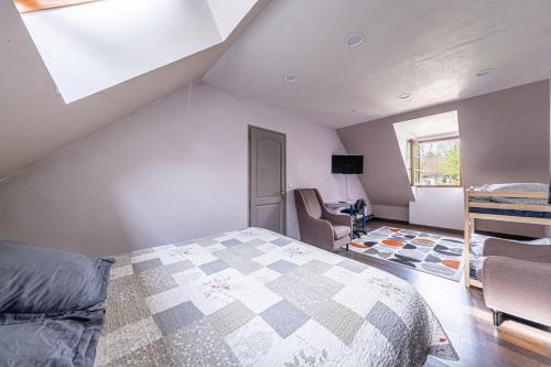 - une chambre mansardée avec un lit et un bureau dans l'établissement Maison Proche Disney/Paris, à Couilly-Pont-aux-Dames