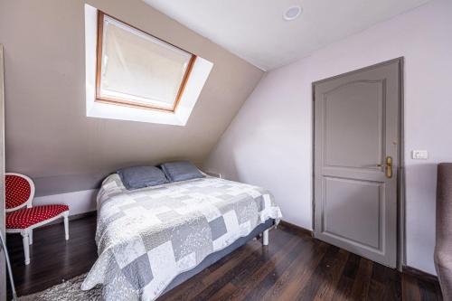 une petite chambre avec un lit et une fenêtre dans l'établissement Maison Proche Disney/Paris, à Couilly-Pont-aux-Dames