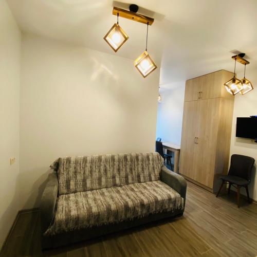 a living room with a couch and a chair at Green House 99 in Batumi