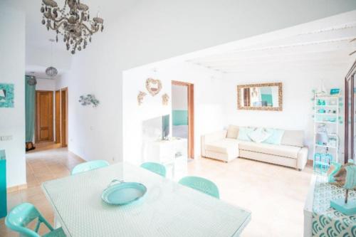 a white living room with a table and chairs at Villa KITE KATE, cozy space, house and garden in La Oliva