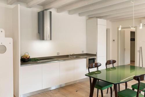 a kitchen with a green table and chairs at La Corte - Appartamento Travail in Tignale