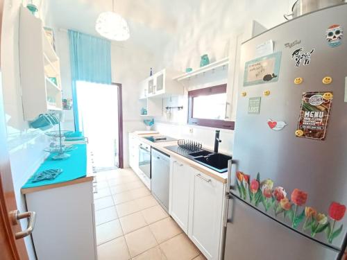 a kitchen with a refrigerator with flowers on it at Villa KITE KATE, cozy space, house and garden in La Oliva