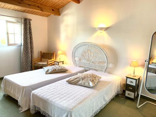 une chambre avec deux lits et une chaise dans l'établissement Maison de la Métairie, à Les Sables-dʼOlonne