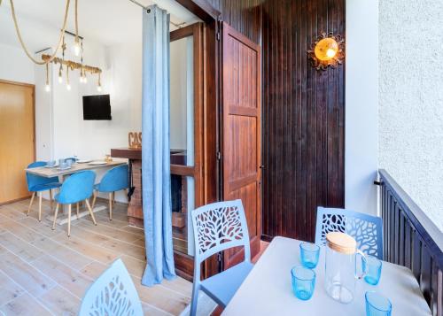 a dining room with blue chairs and a table at Nel Blu - Fancy Mountain Apartment in Maggio