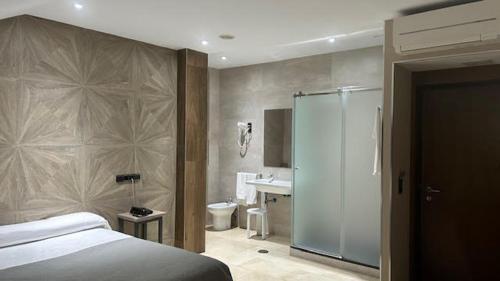 a bedroom with a bed and a bathroom with a shower at Hotel Ciudad de Fuenlabrada in Fuenlabrada