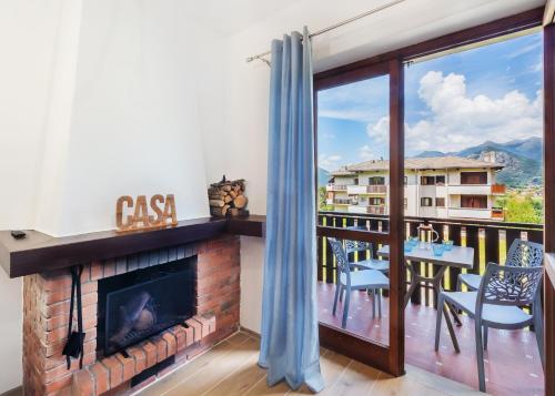a living room with a fireplace and a balcony at Nel Blu - Fancy Mountain Apartment in Maggio