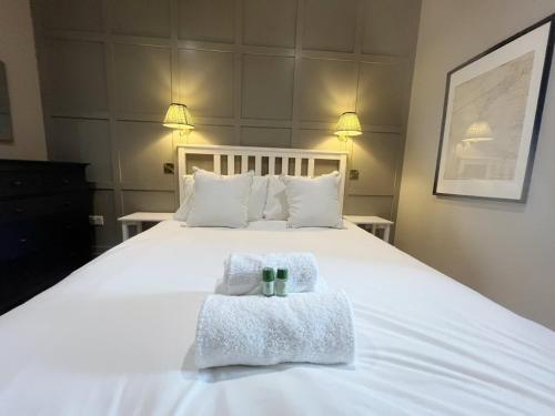 a bedroom with a white bed with towels on it at Number 5 Clevedon in Walton Down
