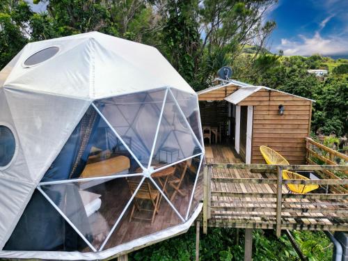 a dome tent on a deck with a cabin at Bubble Dome Village in Saint-Joseph