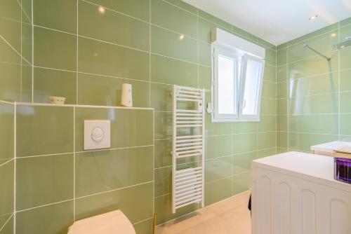 a bathroom with green tiled walls and a shower at Gîte de Mam's - Voie verte in Bazeilles