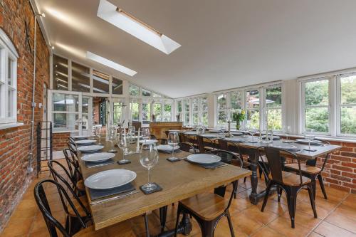 a large dining room with tables and chairs and windows at Catton Old Hall Norwich in Norwich