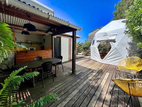 a deck with a table and chairs and a tent at Bubble Dome Village in Saint-Joseph