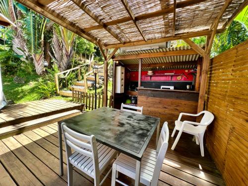 a patio with a table and chairs on a deck at Bubble Dome Village in Saint-Joseph
