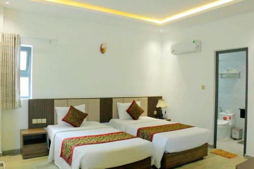 a bedroom with two beds and a mirror at Oliver Hotel in Nha Trang