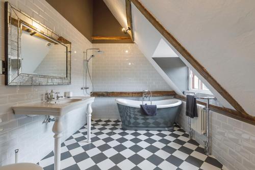 a bathroom with a sink and a bath tub at Catton Old Hall Norwich in Norwich