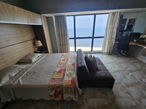 a bedroom with a large bed and a couch at Tropical Executive Luxuoso Vista pro Rio in Manaus