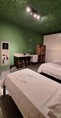 a bedroom with two beds and a green wall at Agualinda Hotel in Alter do Chao