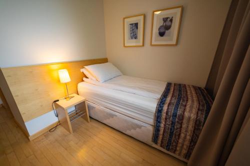 a small bedroom with a bed and a lamp at Dalahótel in Laugar