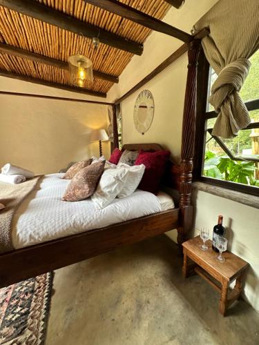 a bedroom with a bed and a window at Stormsriver Backpackers Dijembe in Stormsrivier