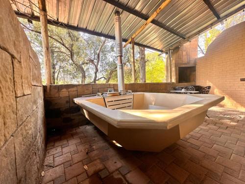 un bagno con ampia vasca e grande finestra di Farm stay at Saffron Cottage on Haldon Estate a Bloemfontein