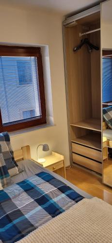 a bedroom with a bed and a large window at Apartmán Husovka Bruntál - pokoj MATYAS in Bruntál