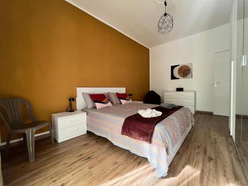 トリノにあるMinù House - Confortevole vicino al Centroのベッドと椅子のある寝室