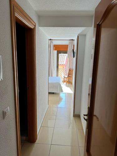 a hallway leading to a bedroom with a bed in a room at Hostal de Cazalegas in Cazalegas