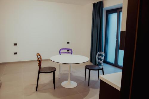 a table and chairs in a room with a window at VicoLetto Bed and Breakfast in Laino Borgo