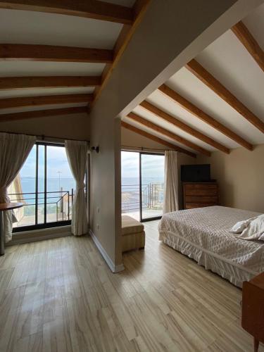a bedroom with a bed and large windows at Casa Murphy in Viña del Mar