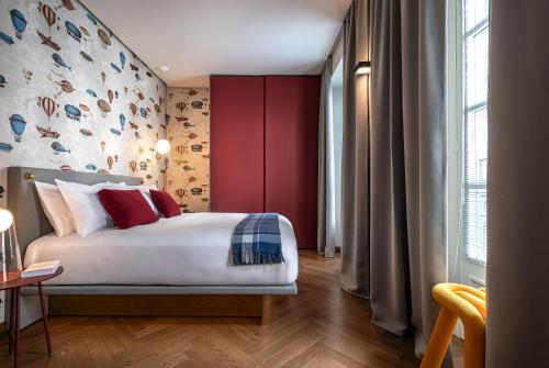 a bedroom with a bed and a red wall at DOMYA - Manzoni 25 in Milan