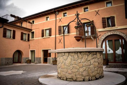 a building with a stone fountain in front of it at Agriturismo Valentina Cubi in Fumane