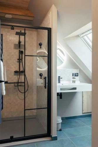 une salle de bain avec une douche avec une porte vitrée dans l'établissement Le domaine de La Combarsou, à Sainte-Féréole