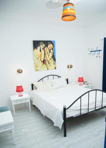 a bedroom with a bed and a painting on the wall at Dar Amazigh in Tozeur