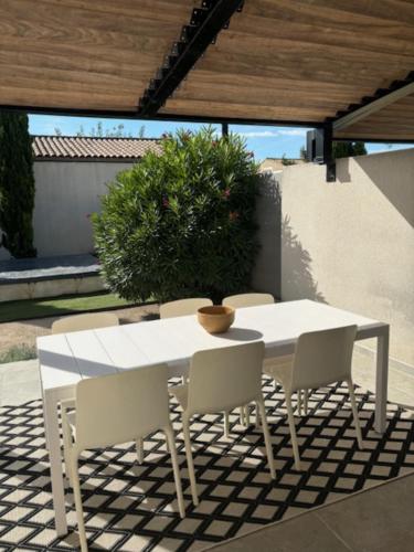une table blanche et des chaises sur une terrasse dans l'établissement Villa Anna - piscine privée proche du centre historique, à LʼIsle-sur-la-Sorgue