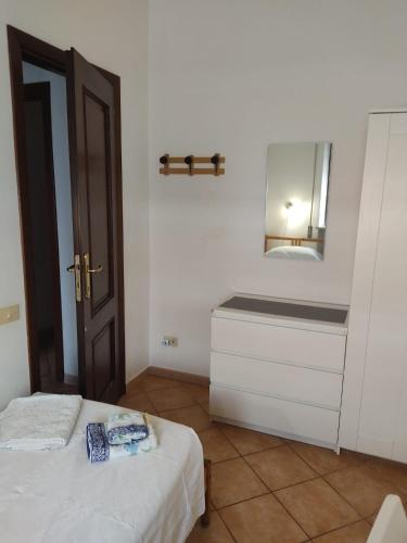 a bedroom with a bed and a mirror on the wall at Stanza singola con bagno personale in Torvaianica
