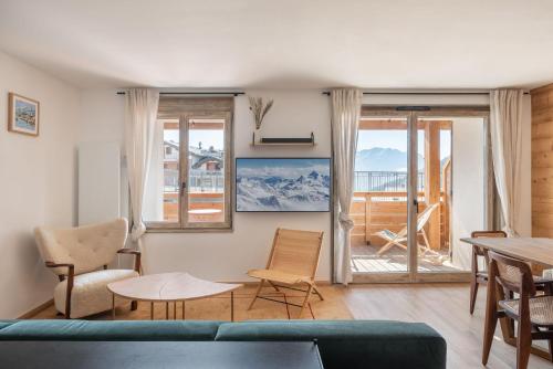 un salon avec un canapé, des chaises et une table dans l'établissement Apartment Bavella Alpe d'Huez - by EMERALD STAY, à Huez