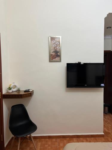 Una televisión o centro de entretenimiento en Sufara Hotel Suites