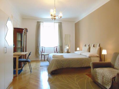 sypialnia z łóżkiem, krzesłem i oknem w obiekcie Affittacamere San Lazzaro w Trieście