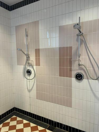a tiled bathroom with two showers and two sinks at Beautiful Yurt with stunning South Downs views in Graffham