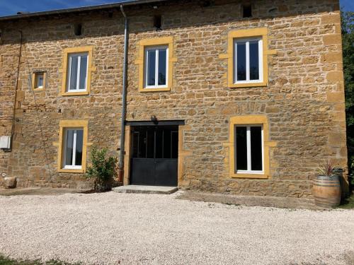 a brick building with a black door and windows at Gîte Domaine du Berret 8 pers in Bully