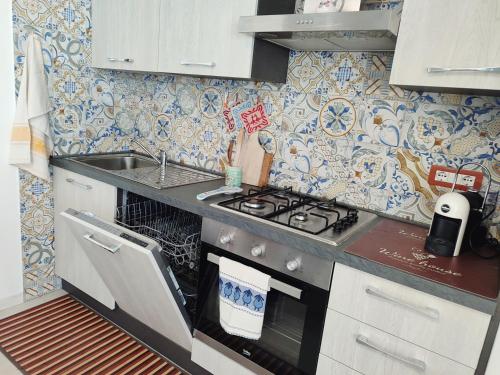 a small kitchen with a stove and a sink at Da Tziu Efisiu Mare e Relax nel Sinis in Baratili San Pietro