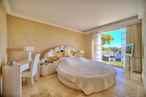 une chambre avec un lit, un bureau et une fenêtre dans l'établissement Ref PRESTIGE by Palmes d Or Properties, à Mougins