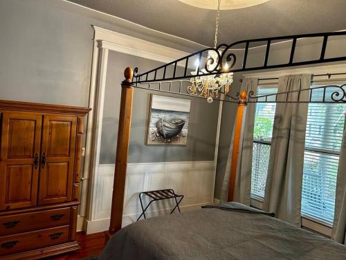 a bedroom with a canopy bed and a chandelier at Tuscawilla B -Beautiful 3 bedroom apt Historic Ocala 1891 in Ocala