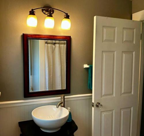 a bathroom with a white sink and a mirror at Tuscawilla B -Beautiful 3 bedroom apt Historic Ocala 1891 in Ocala