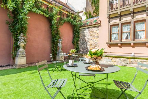 a patio with a table and chairs in a yard at Le 1615 - Luxe et Spa in Colmar