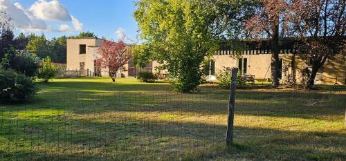 a house in a yard with a sign in the grass at Le haras de gus et lulu in Guémardières