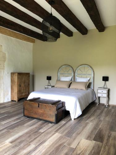 a bedroom with a bed and a wooden floor at Le Gîte de Marie in Saint-Front-la-Rivière