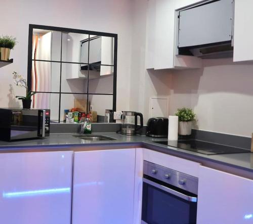 a kitchen with a sink and a microwave at Cosy City Centre Apartment with Parking in Birmingham